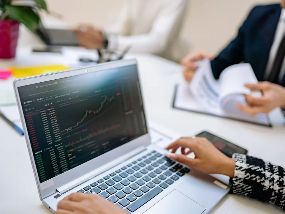 Fachpersonen besprechen gemeinsam eine Finanzierung an einem Laptop.